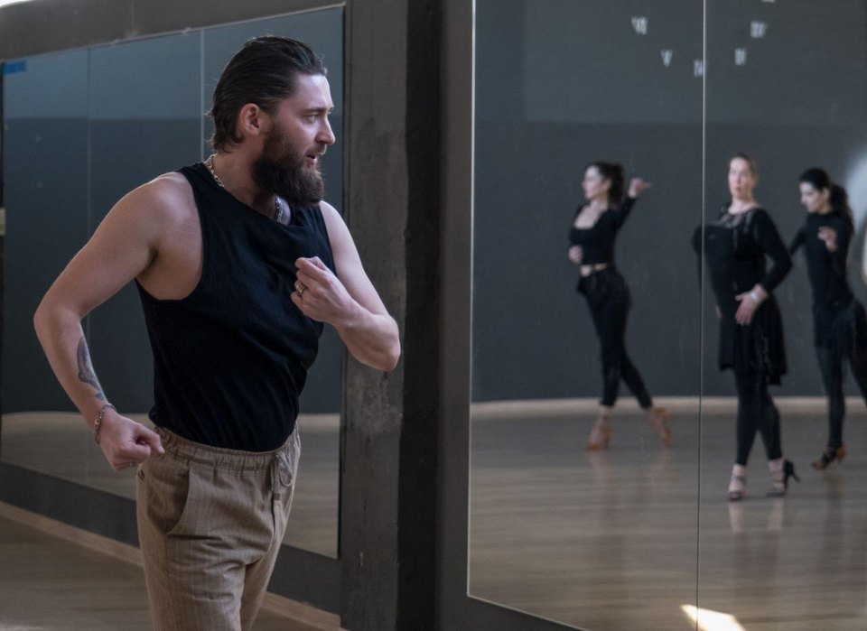 Зал школы танцев DanzAventura: зеркальная стена, паркет и группа на занятии